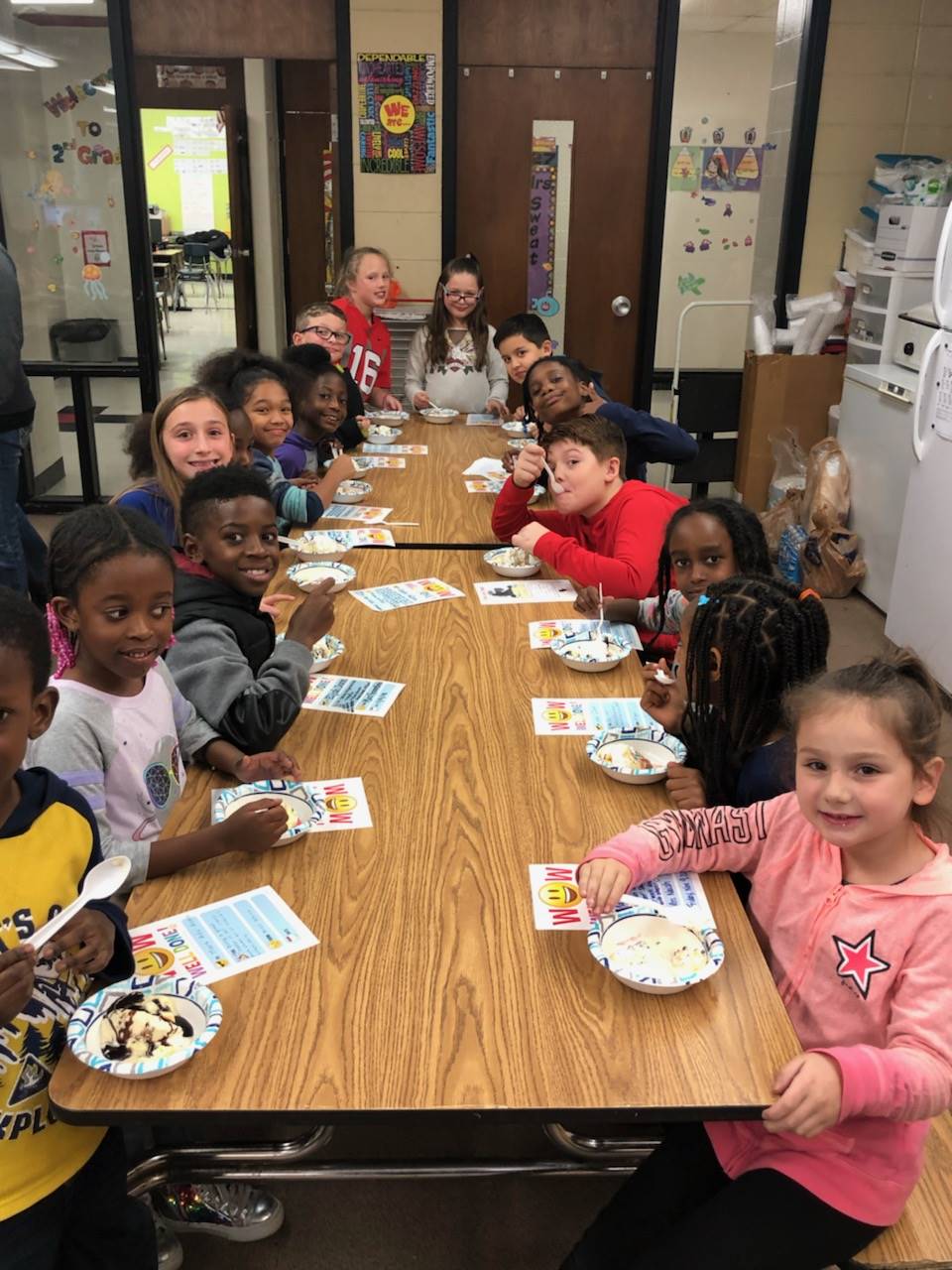 students sitting at a table eating ice cream