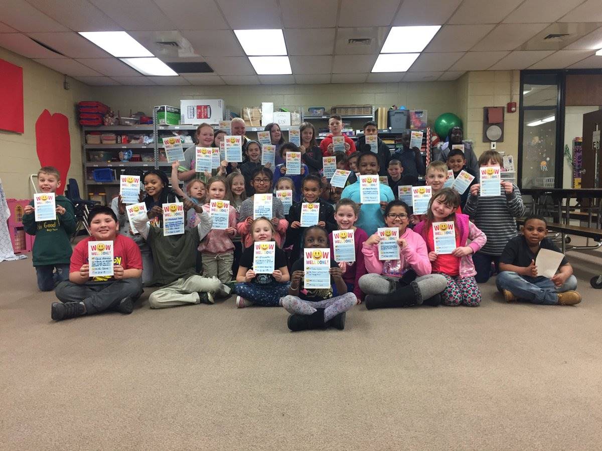 students in a group holding up tickets from their teachers