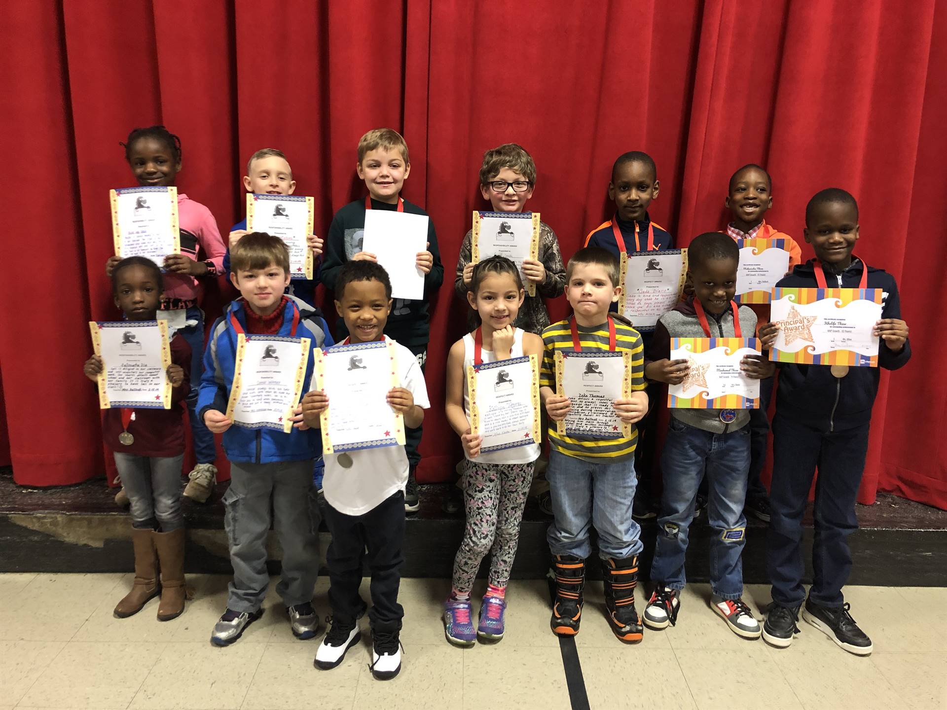 students holding paper certificates