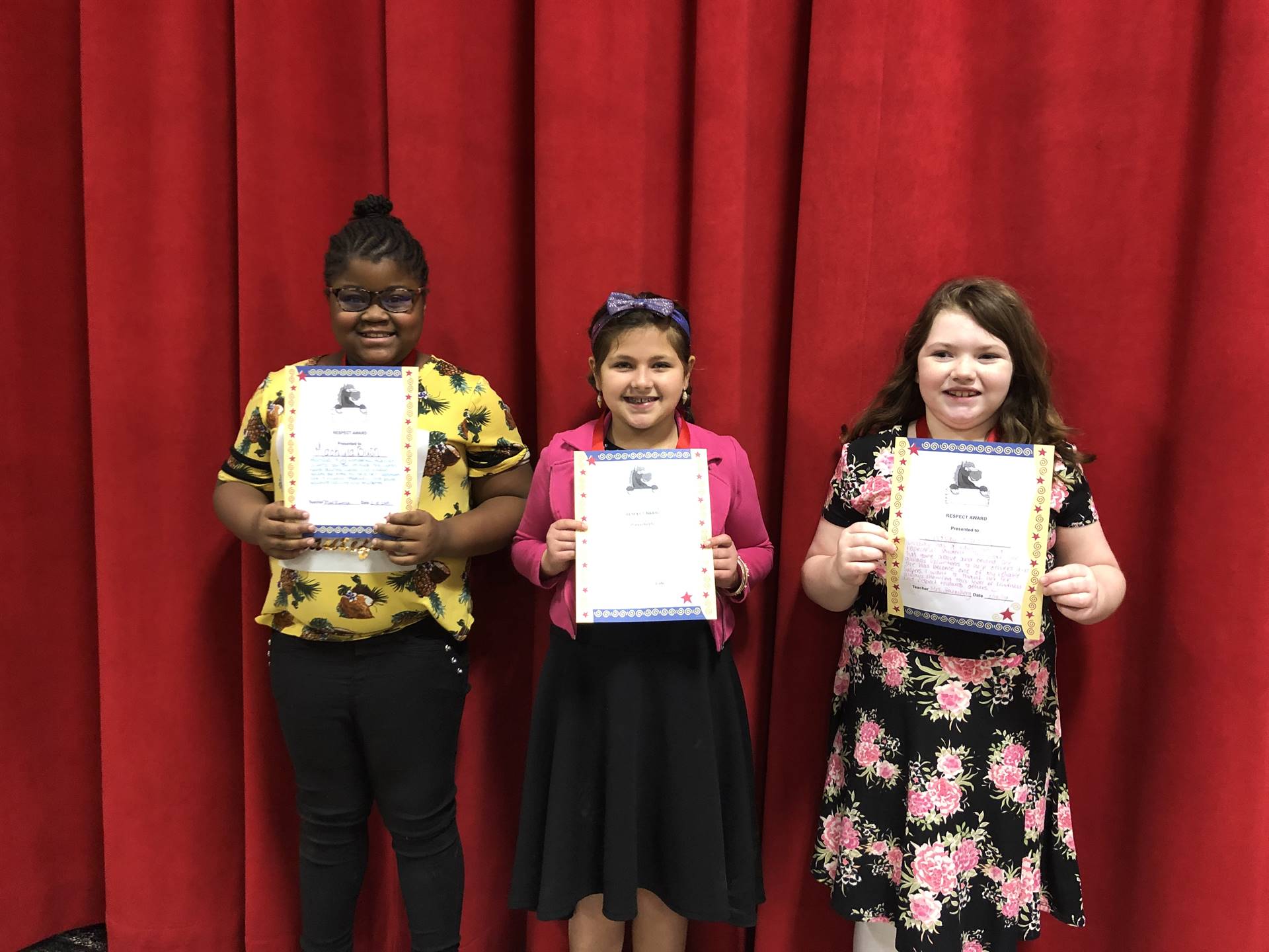 students holding paper certificates