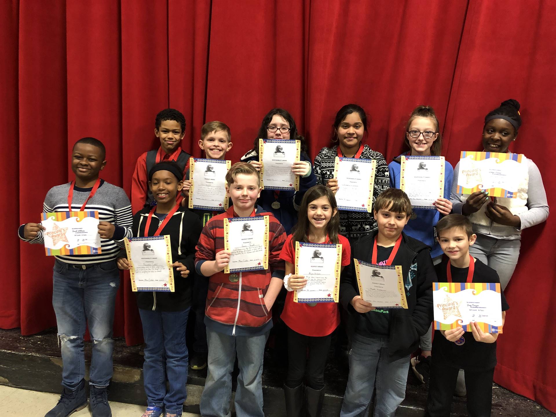 students holding paper certificates