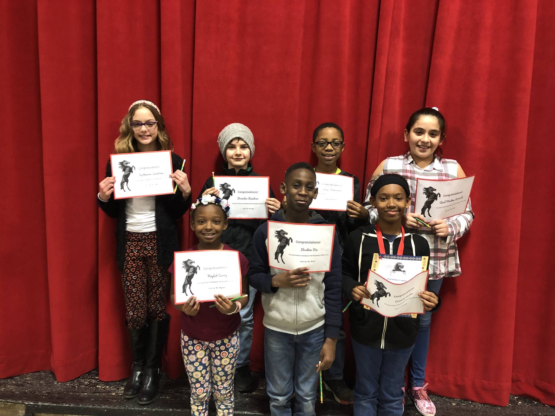 students holding paper certificates