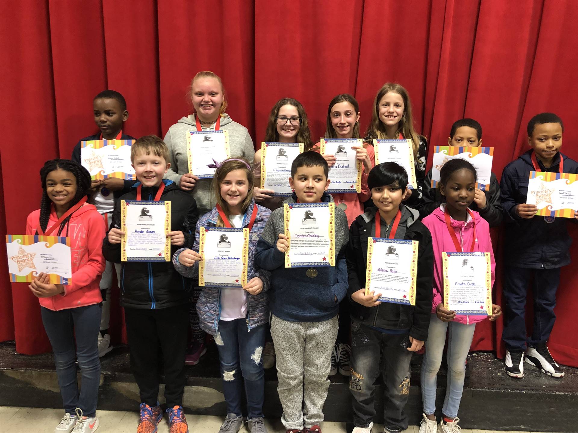 students holding paper certificates