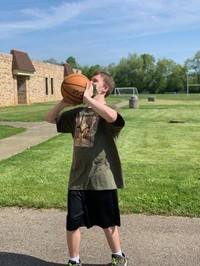 student shooting a basket