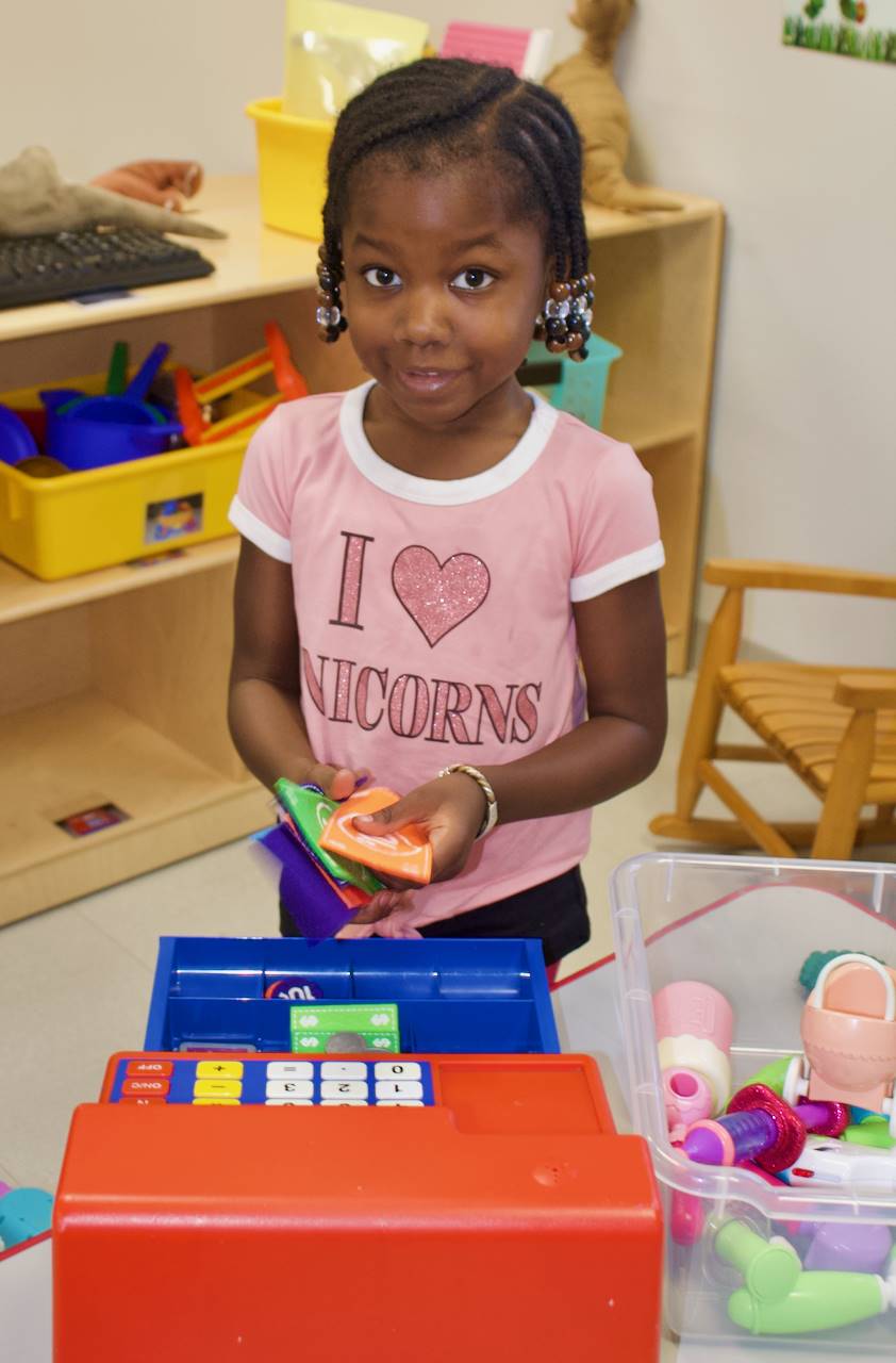 preschool girl playing with cash register