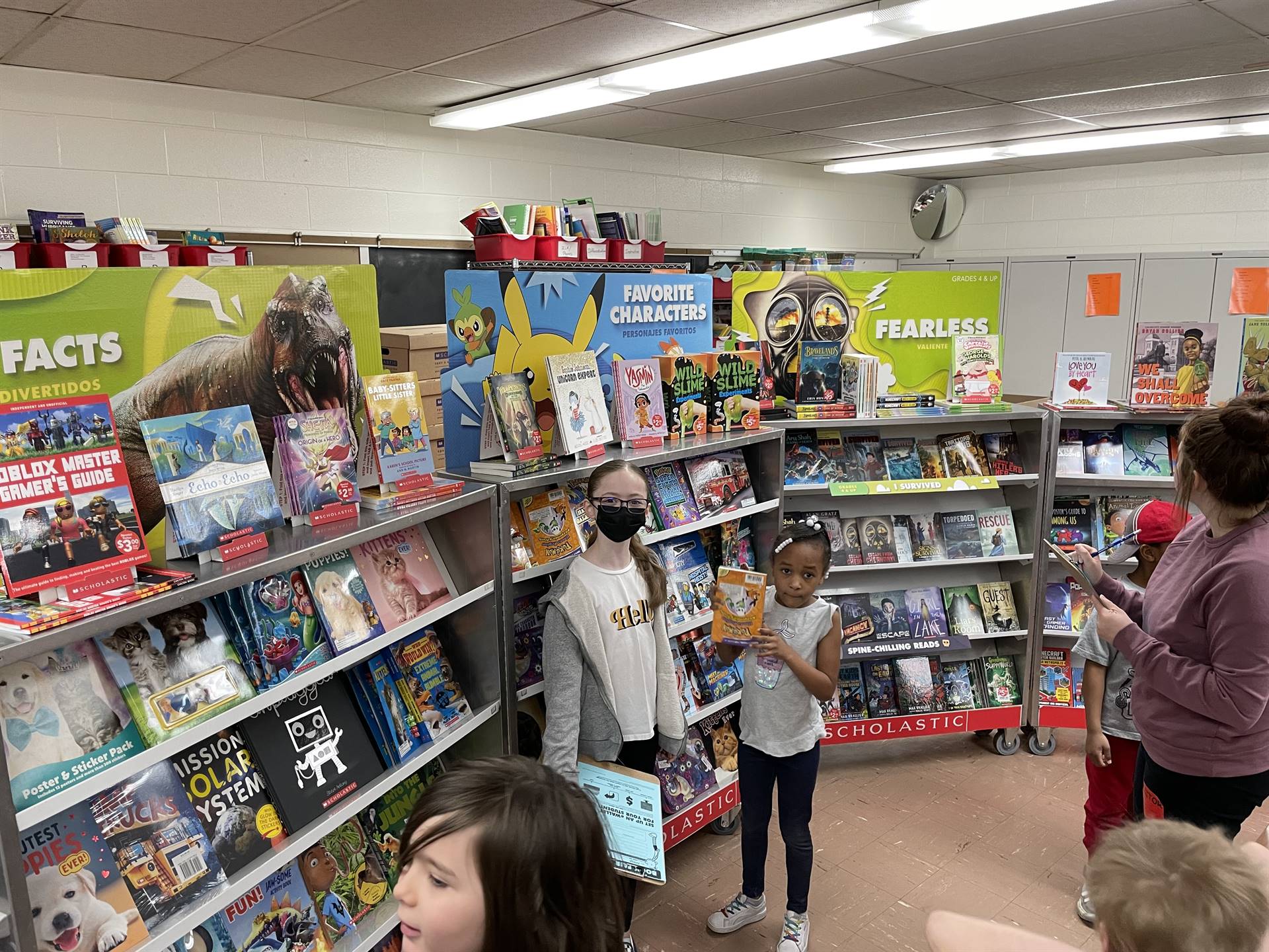 5th Grade Girls helping younger students at the book fair.