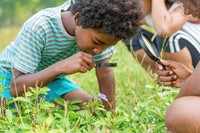 boy exploring nature with magnifying glass